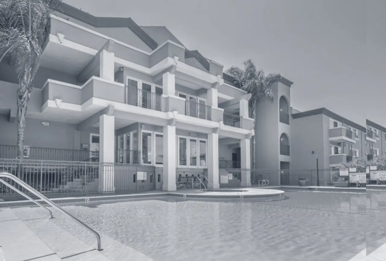The Breakwater apartment community in Huntington Beach, California — a landscaped pool and a three-story residential building.